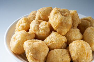 Close-up of a bowl of golden tempting fried tofu with avocado oil