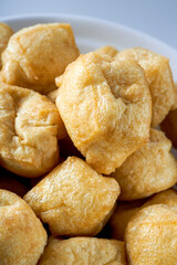 Close-up of a bowl of golden tempting fried tofu with avocado oil