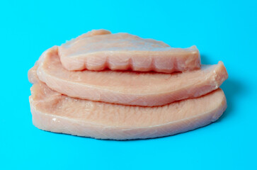 fresh turkey steaks on blue background