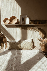 Modern boho style home interior design. Bohemian bedroom with bed, pillows, straw and rattan...