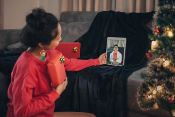 Woman making video call on social network and giving Christmas gift on Christmas day. Happy girl celebrating Christmas from social network.