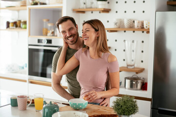 Young couple making sandwich at home. Loving couple enjoying in the kitchen.