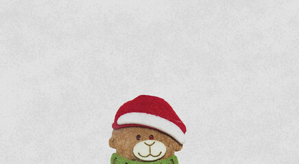 Toy bear in a Christmas red hat 
on gray background