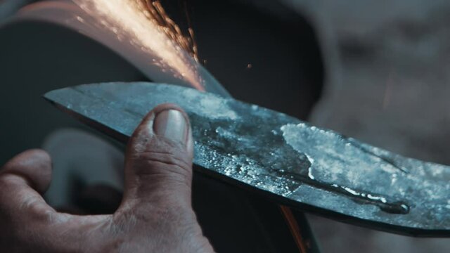 Top view of a knife sharpening operation, with sparks