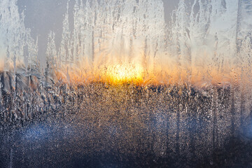 Frosty pattern on glass in the setting sun