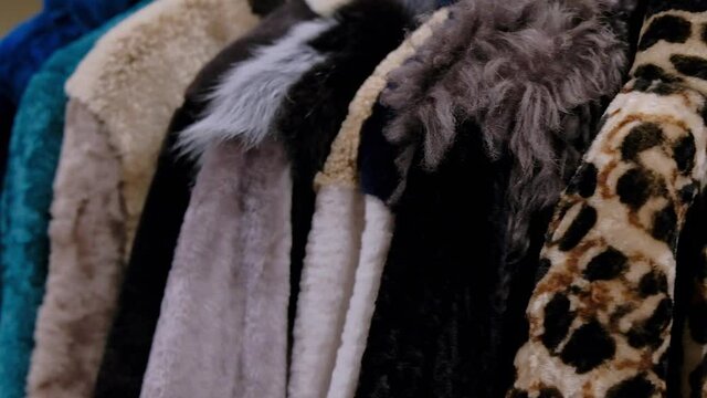 Wool warm winter coats for winter sale on a clothes rack in a retail fashion store. Wool coats collection close up