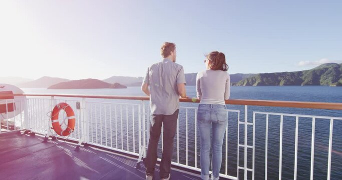 New Zealand travel people enjoying nature view of ferry boat cruise in Marlborough Sounds trip from Picton to Wellington, Cook strait crossing. Couple tourists watching sunset vacation.