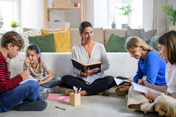Group of homeschooling children with teacher studying indoors, coronavirus concept.