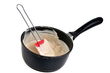Fototapeta na wymiar Casserole de sauce béchamel avec une spatule en gros plan sur fond blanc