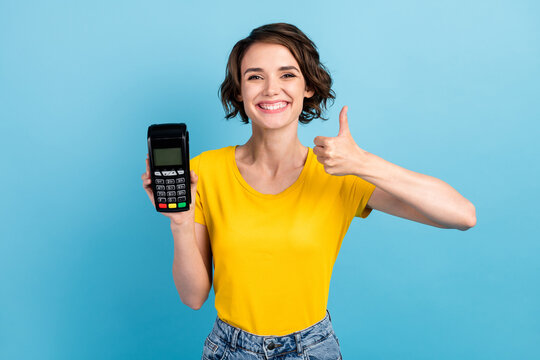 Photo of positive girl hold card reader raise thumb up wear yellow t-shirt isolated blue color background