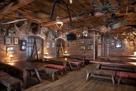 A hotel with old fashioned retro styled rooms, and rustic objects, cafe with tables and benches. 