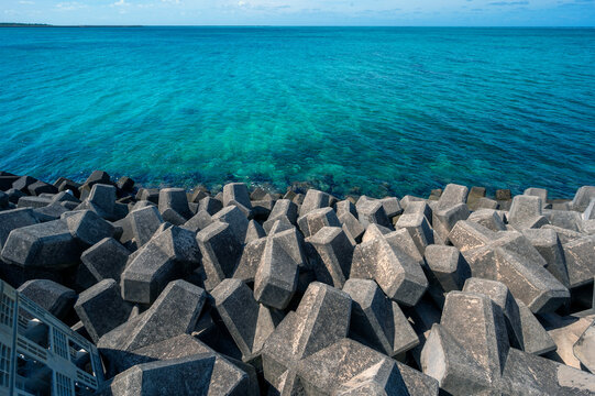 Concrete tetrapod sea defense barrier contrasts with turquoise waters and a coral reef on the island of Irabu, Miyakojima, Okinawa
