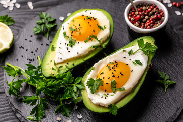 Homemade Organic Egg Baked in Avocado with Salt and Pepper. Avocado stuffed with eggs. Delicious breakfast or snack. top view