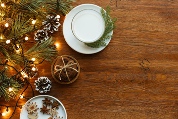 Obraz na płótnie Canvas Glass of milk and stack of chocolate chip cookies on wooden table prepared for Santa Claus on Christmas Day 