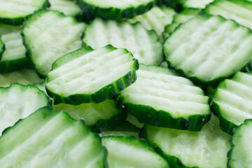 food background with slices of fresh green cucumber