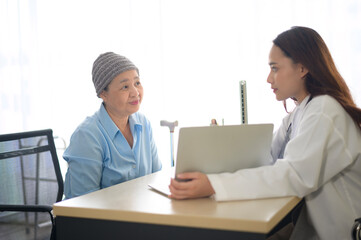 Obraz premium Cancer patient woman wearing head scarf after chemotherapy consulting and visiting doctor in hospital.
