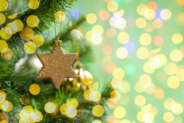 Christmas decoration golden twinkling star on a branch of a christmas tree, christmas tree toy,...