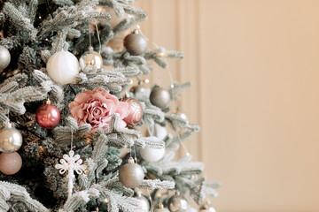 Christmas tree decorated with balls and glass toys. Light background.