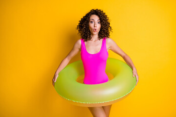 Photo of attractive funny terrified lady relax rest resort prepare swim big round circle afraid step into water frightened face wear pink swimsuit isolated vivid yellow color background
