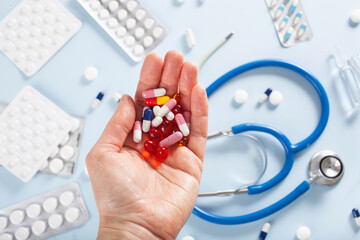 hand holding pills, stethoscope syringe capsule medicine. medical treatment for flu virus
