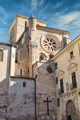 Fototapeta na wymiar Cuenca cathedral side, cross on stone wall and entrance to the diocese of the city, Spain