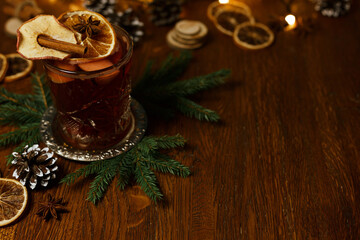Hot mulled wine with dried orange slice and cinnamon stick in glass on wooden table prepared for Christmas celebration 