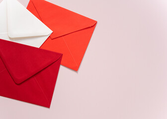 red and white envelopes on pink background