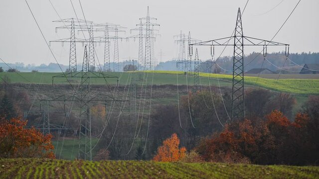 Large transmission towers in the countryside. Different types of electricity pylons in the countryside. Large electricity poles in an autumn landscape.