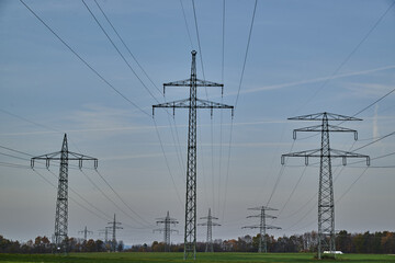 Large transmission towers in the countryside. Different types of electricity pylons in the countryside. Large electricity poles in an autumn landscape.
