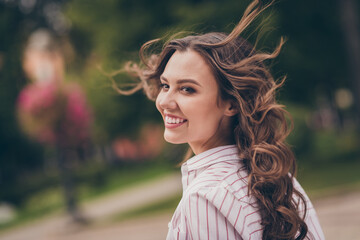 Profile photo of adorable optimistic young woman smiling long curly hair walking park wear white striped shirt outdoors