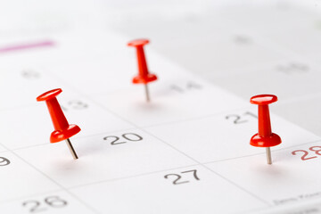 red buttons on the calendar. Concept idea for planning. An important date, business trip, or meeting reminder.