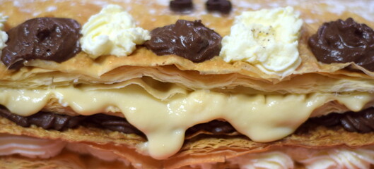 close-up chocolate cake, puff pastry and cream falling apart