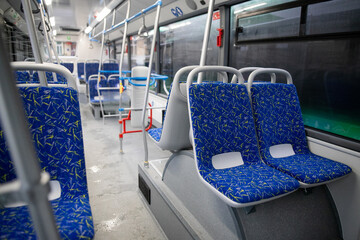Naklejka premium Empty bus interior. Blue seats without passengers. Public transport. Transportation of passengers by public transport. Ergonomic interior of the bus. Travel to other cities.