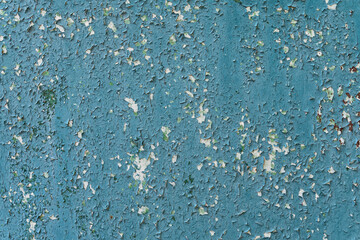 Old paint on the wall. Textured abstract background. cracked blue pain.