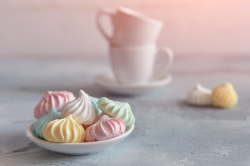 Meringues of a delicate pastel color are on the table for morning tea