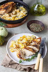 Oven baked or grilled spicy chicken breast with pumpkin and aromatic herbs on a ceramic plate. Healthy food.