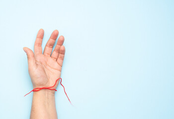 Naklejka premium red woolen thread on the wrist of a female hand