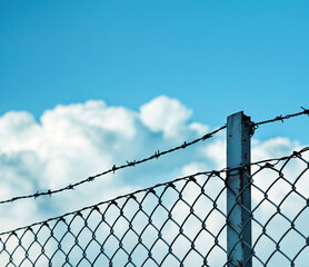 Barbed wire fence on a promise sky