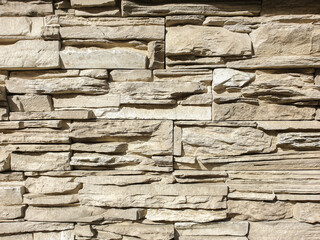 Abstract background . Brown stone wall close up. Folded stone wall background horizontal. Facing with a stone wall. Selective focus