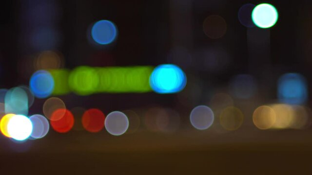 Defocused night traffic, blurred bokeh image of a city with cars passing