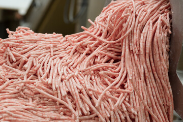 Minced meat being extruded from an industrial mincing machine