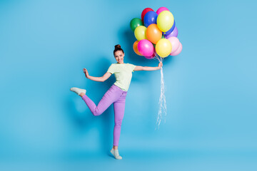 Fototapeta na wymiar Full length body size photo of funny girl holding pile of colorful air balloons smiling happily isolated on vibrant blue color background