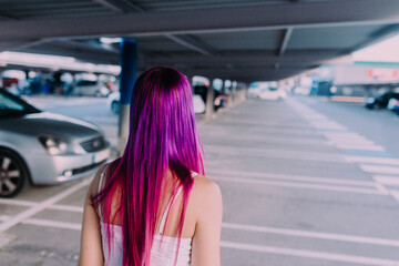 Fototapeta premium attractive young woman with dyed purple hair and big eyes walking on the street 