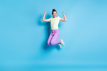 Fototapeta na wymiar Full length body size photo of pretty girl jumping high laughing showing strong arms smiling isolated on vibrant blue color background