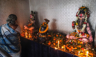 Siliguri, India - November 2020: Woman making offering at the Sashan Kali Temple in Siliguri on...