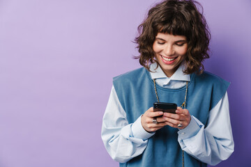Joyful beautiful girl using smartphone and smiling