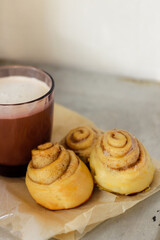 coffee with cream in a clear glass and cinnamon rolls, copy space