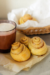 Obraz na płótnie Canvas Homemade buns with coffee for breakfast. Cinnamon buns. Coffee with foam. Cinnabon