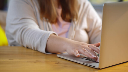 Close up of fat woman typing on laptop working or shopping online at home