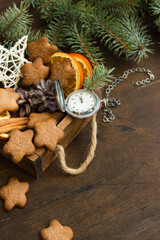 Handmade Christmas decorations and branches of a Christmas tree on a wooden table. Template for design in eco style. Christmas background with fir tree, gingerbread cookies, Christmas toys